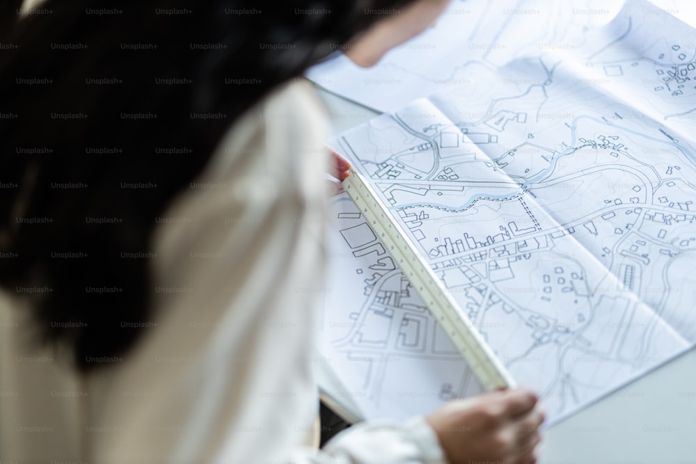 a woman looking at a map with a pencil in her hand