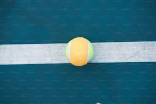 a tennis ball sitting on top of a tennis court