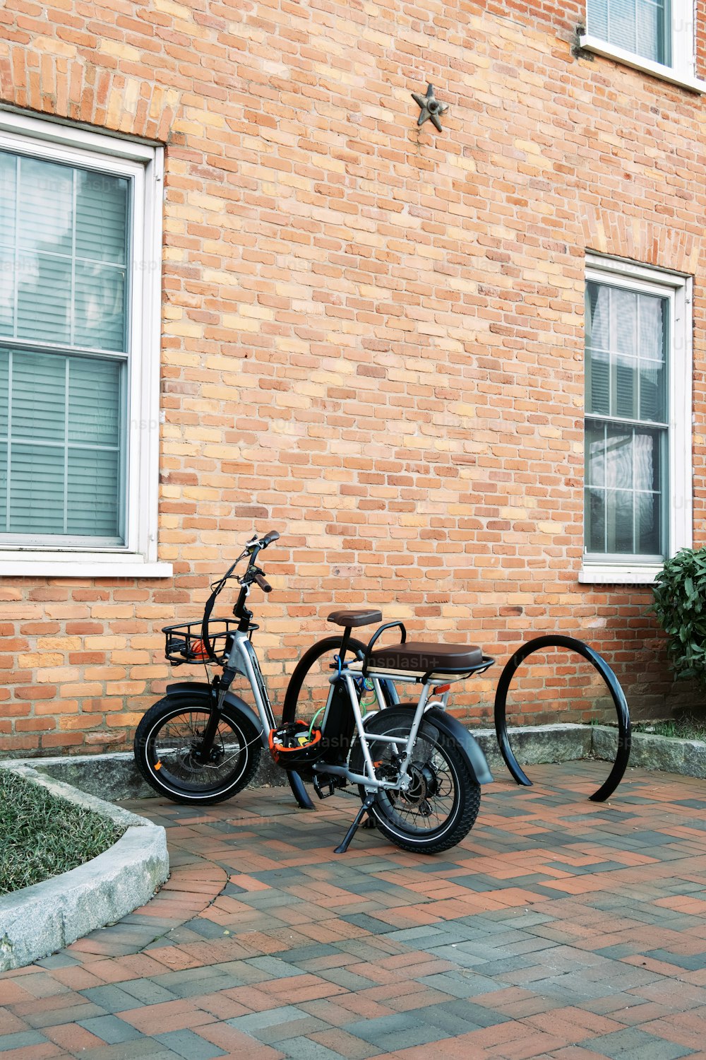 a couple of bikes parked next to a brick building