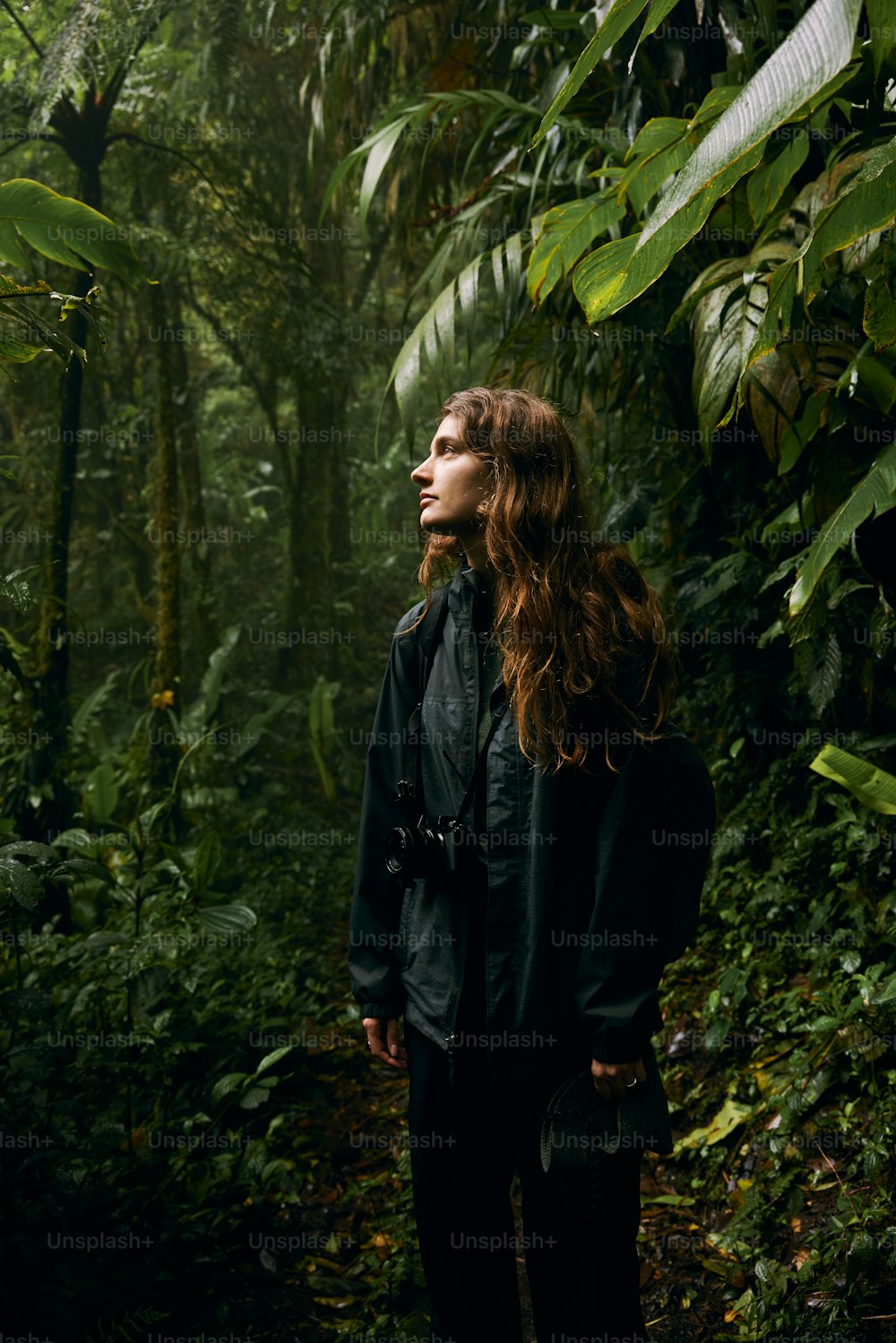 a woman standing in the middle of a forest