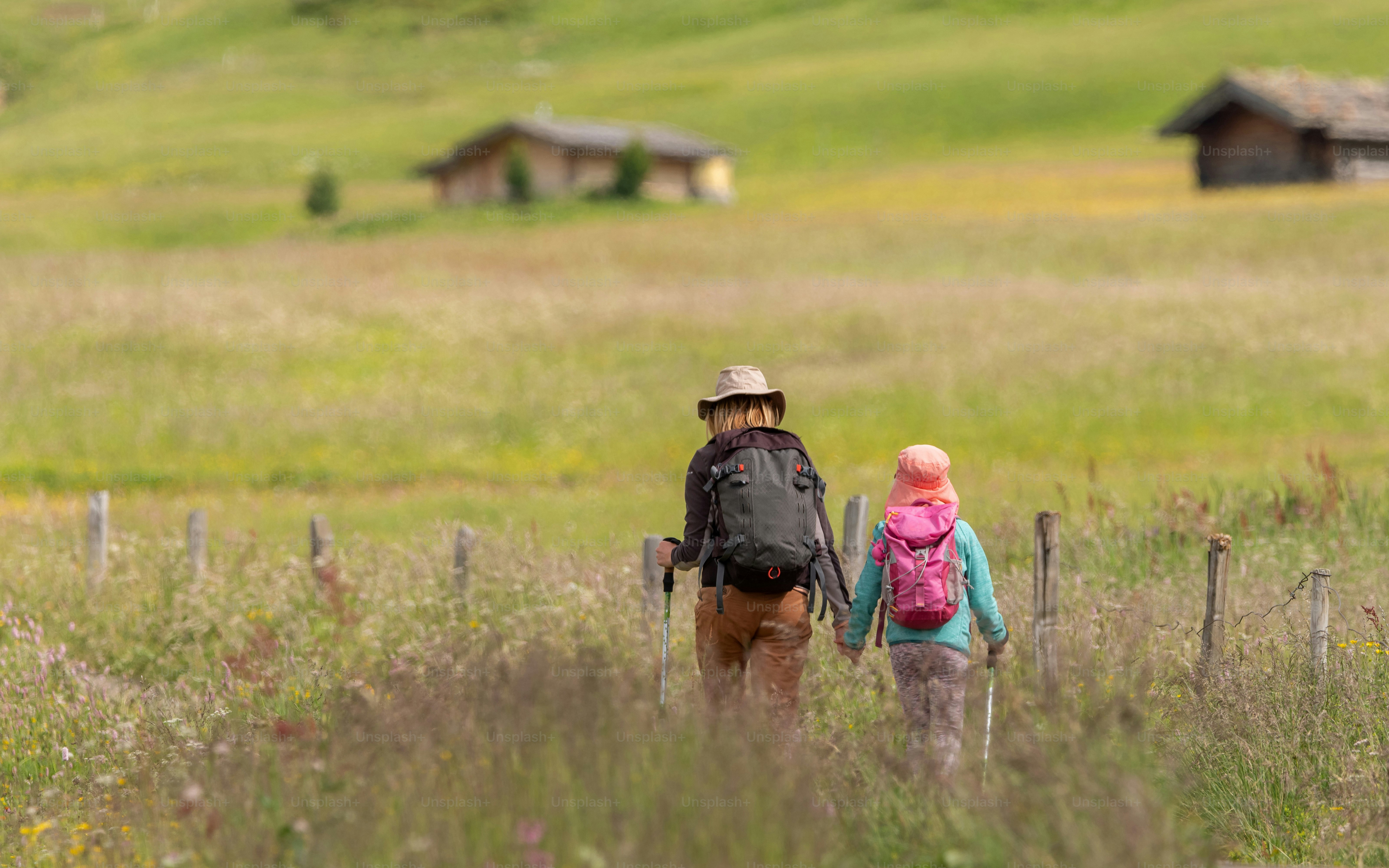 A female hiker and her daughter trekking in the Dolomites mountains in Italy.