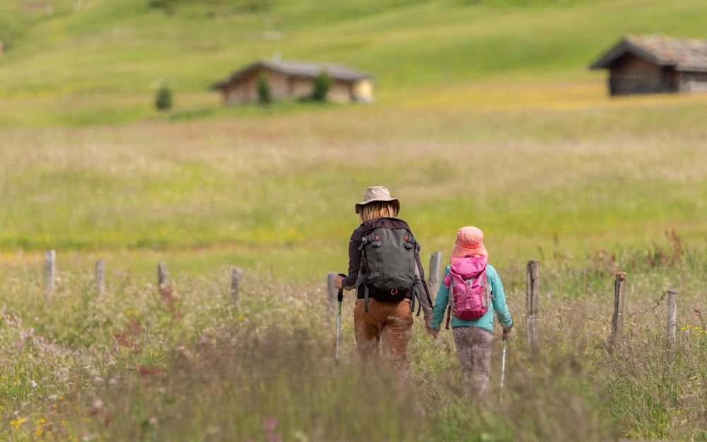 a man and a little girl walking through a field
