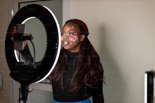 a woman with face paint holding a camera
