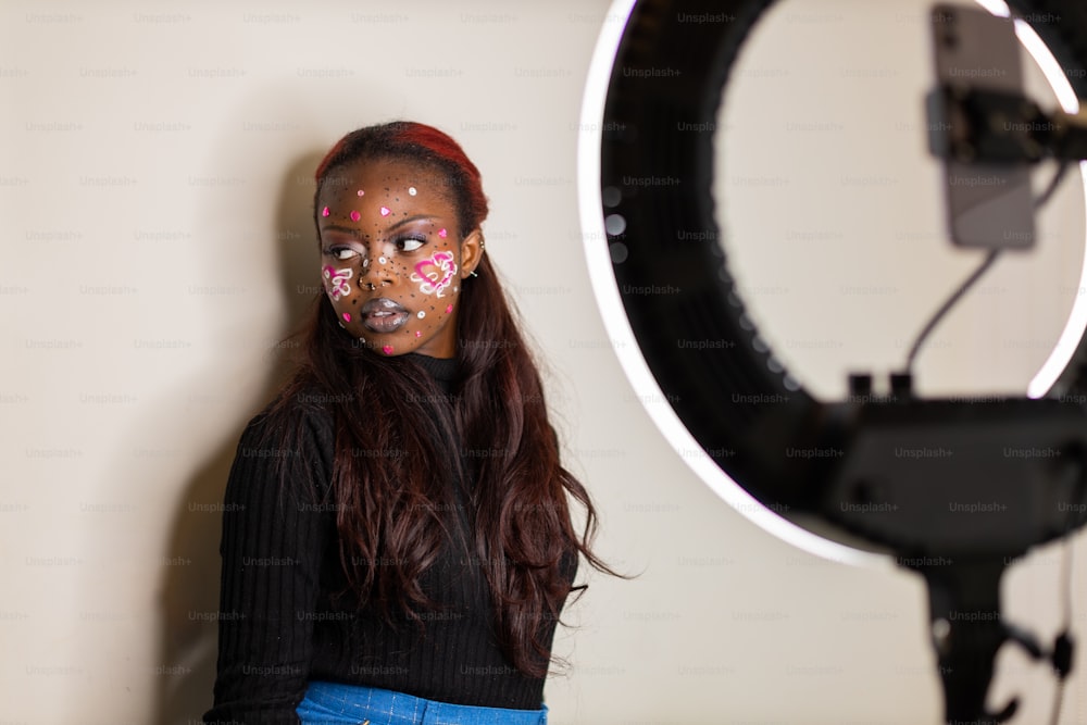 Une femme avec de la peinture faciale debout devant une caméra