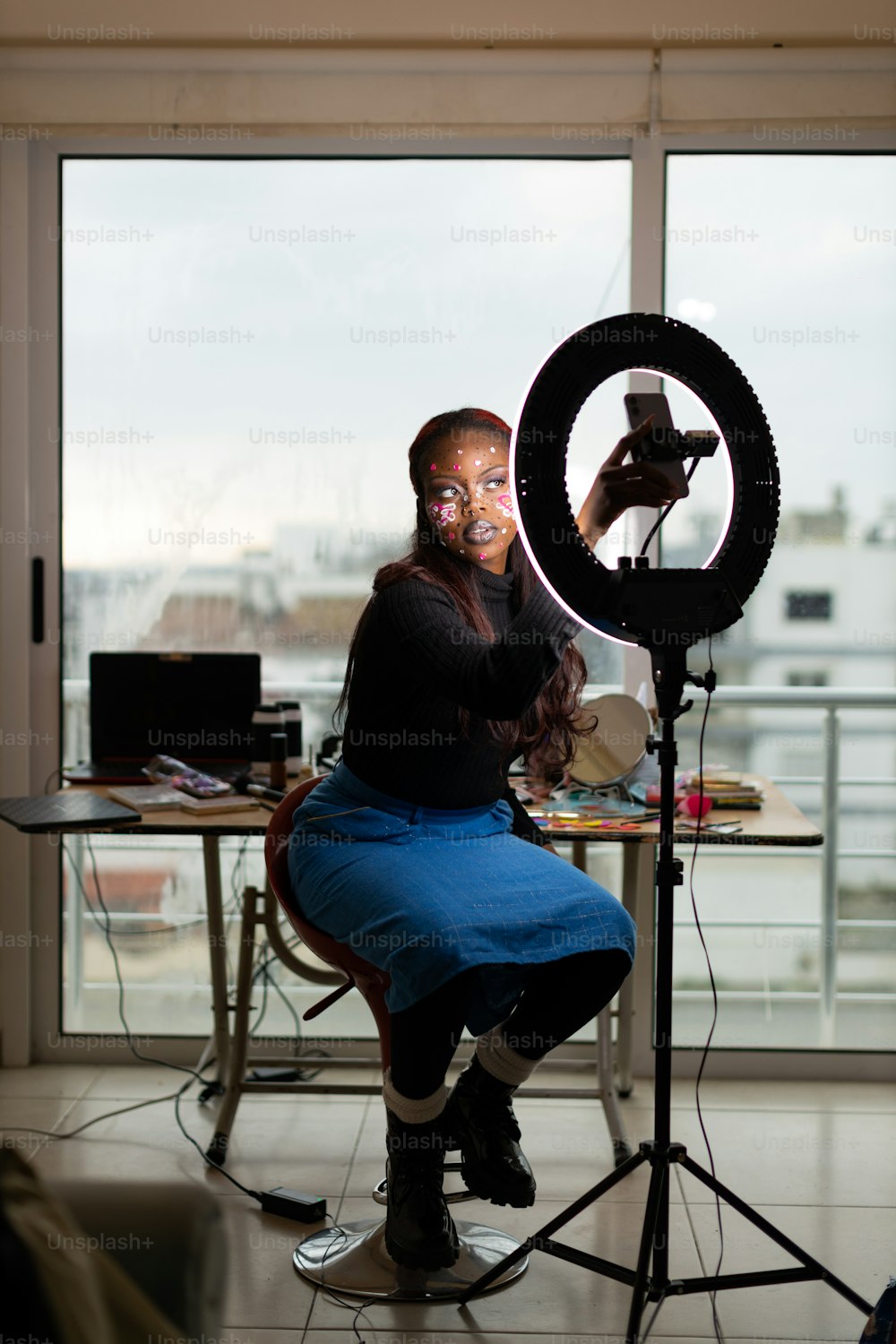 a woman sitting in front of a camera taking a picture