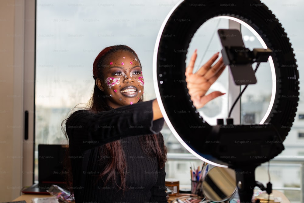 a woman with face paint holding up a camera
