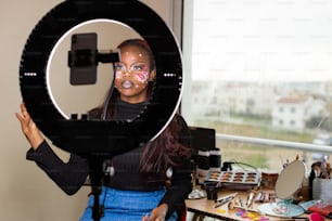 a woman with face paint is holding a camera
