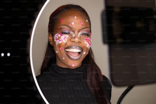 a woman with a face painted with pink and white sprinkles