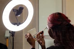 uma mulher está fazendo maquiagem na frente de um espelho