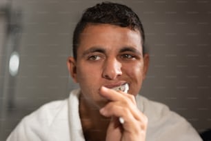 a man brushing his teeth with a tooth brush