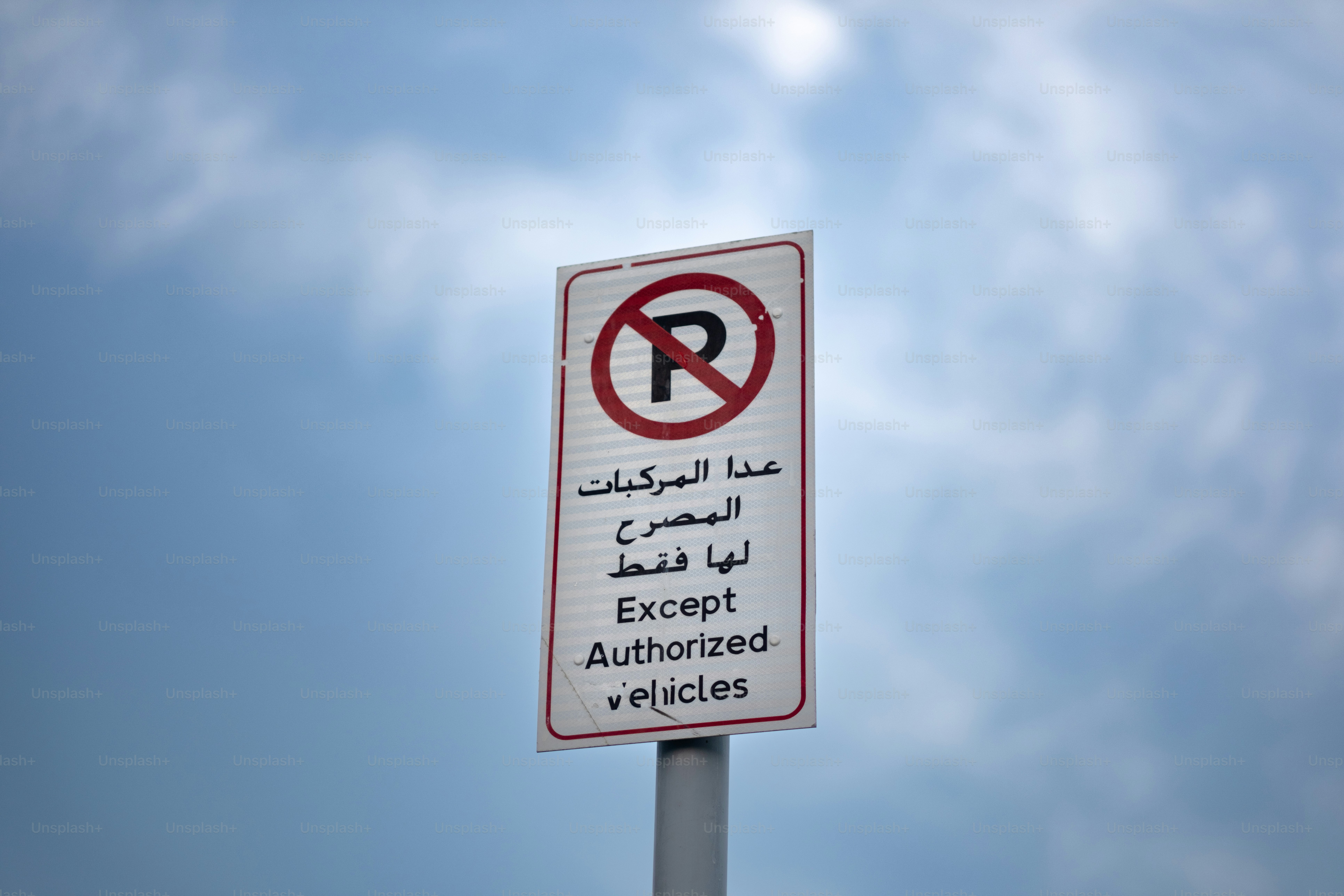 A 'no parking' sign in English and Arabic.