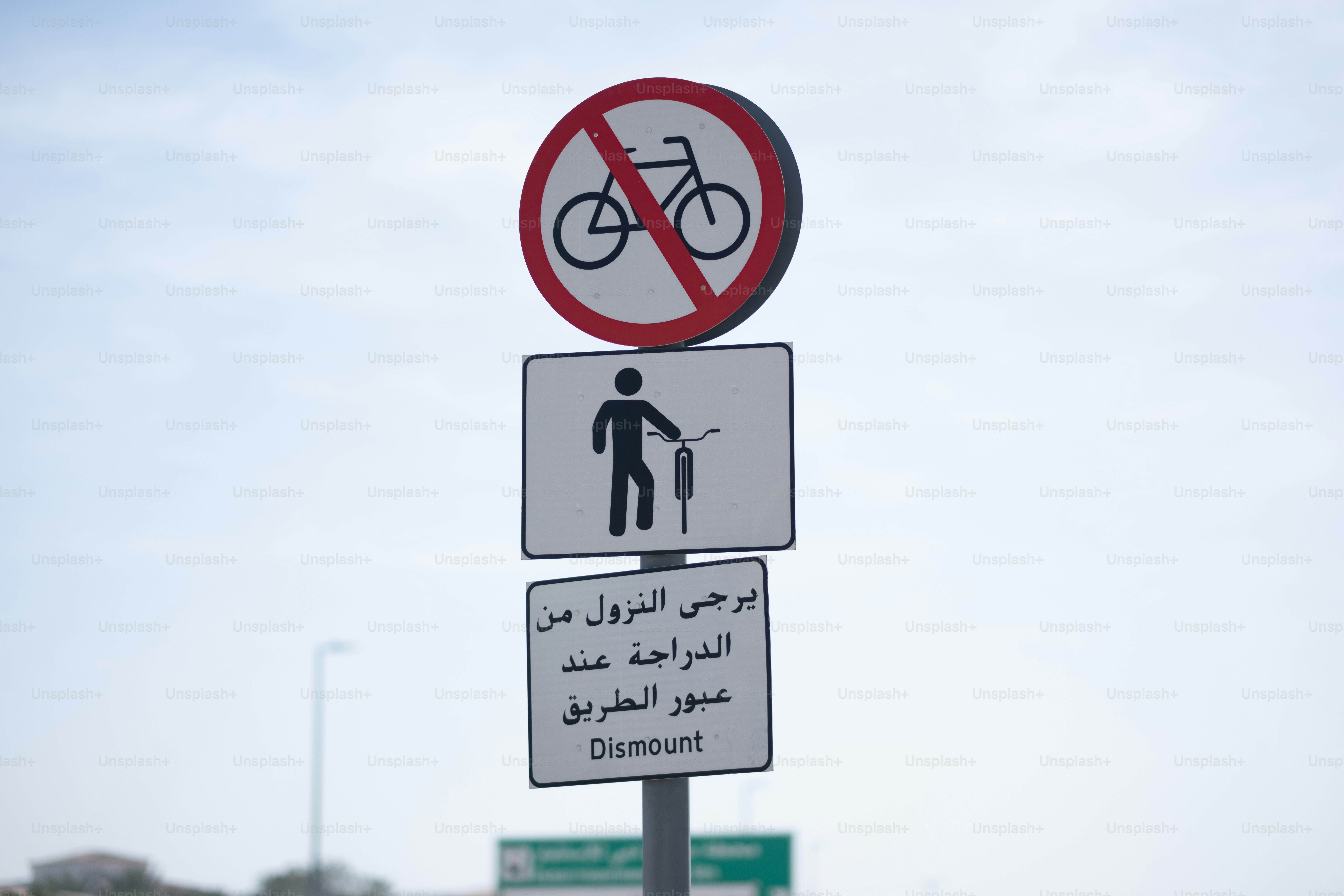 A sign for pedestrians only (dismount bicycles) in English and Arabic.