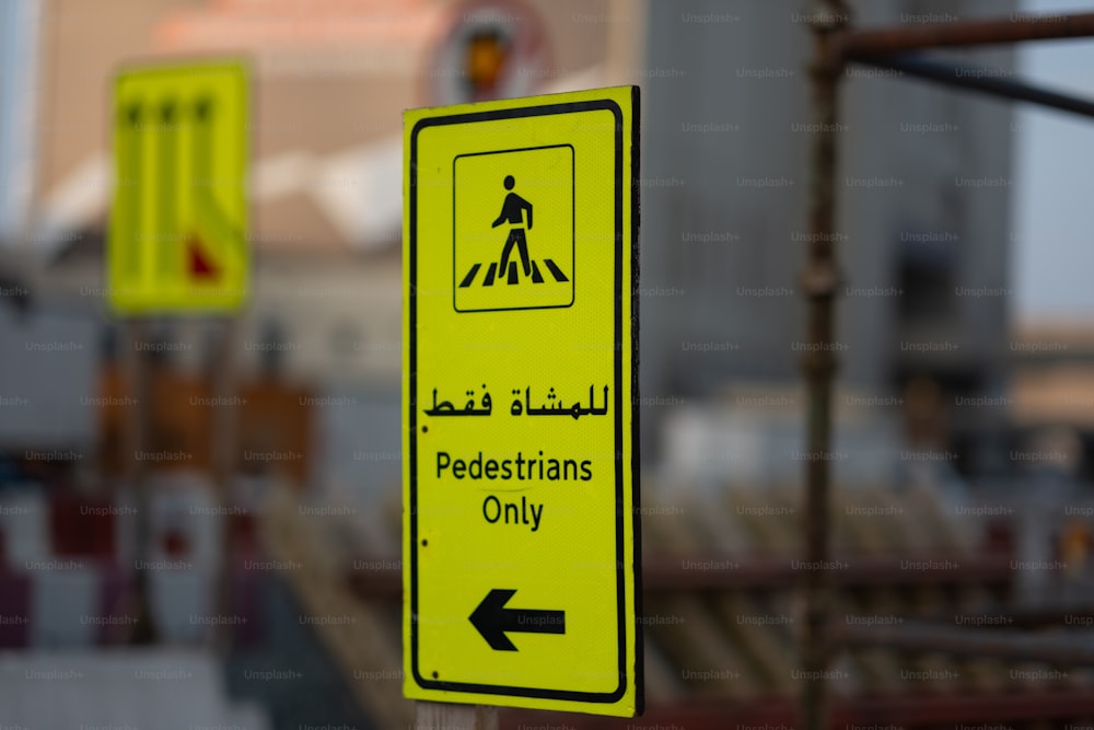 a yellow pedestrian only sign sitting on top of a wooden pole