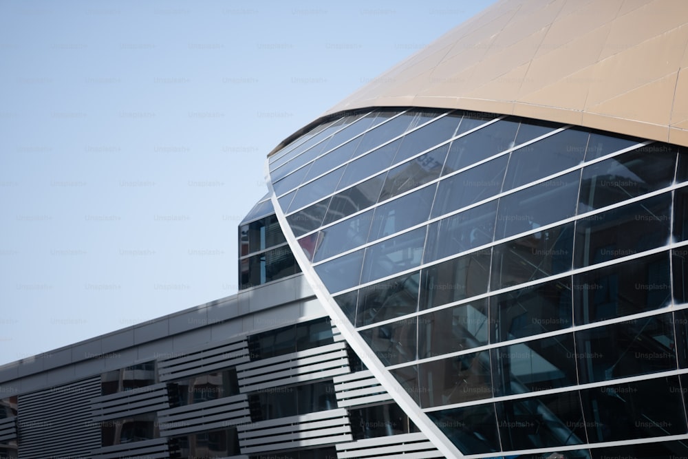 a large building with a curved roof next to a tall building