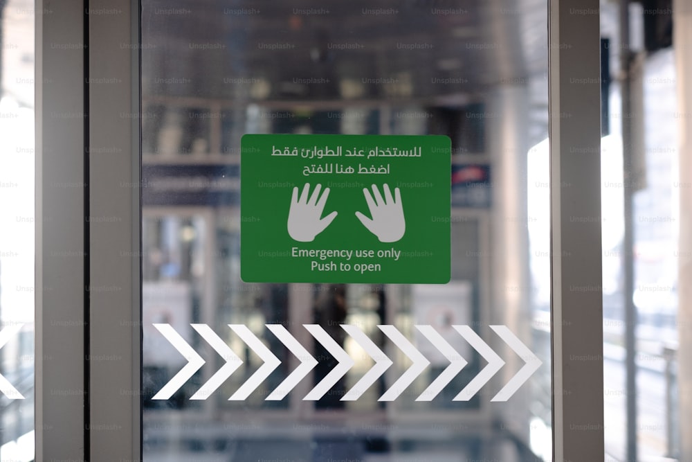 a green and white sign on a glass door