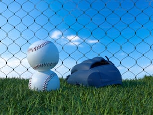 Una pelota de béisbol y un guante de receptor sentado en la hierba