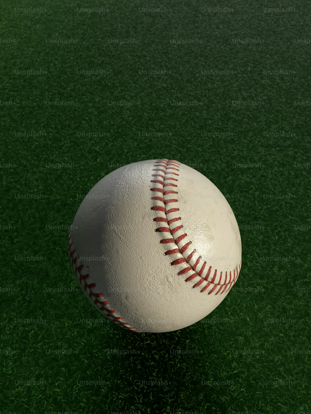 uma bola de beisebol branca sentada em cima de um campo verde