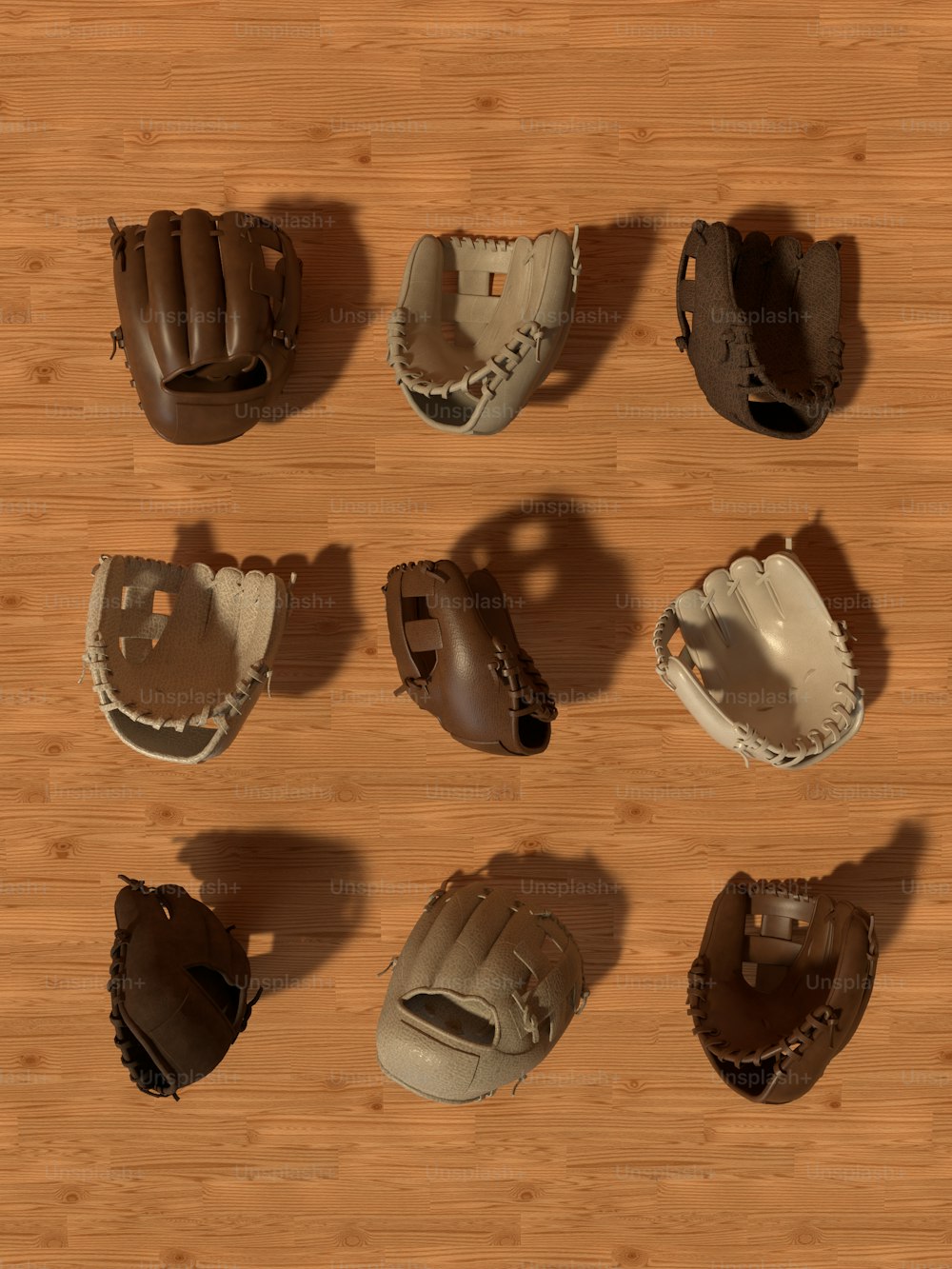 un gruppo di guanti da baseball seduti sopra un pavimento di legno