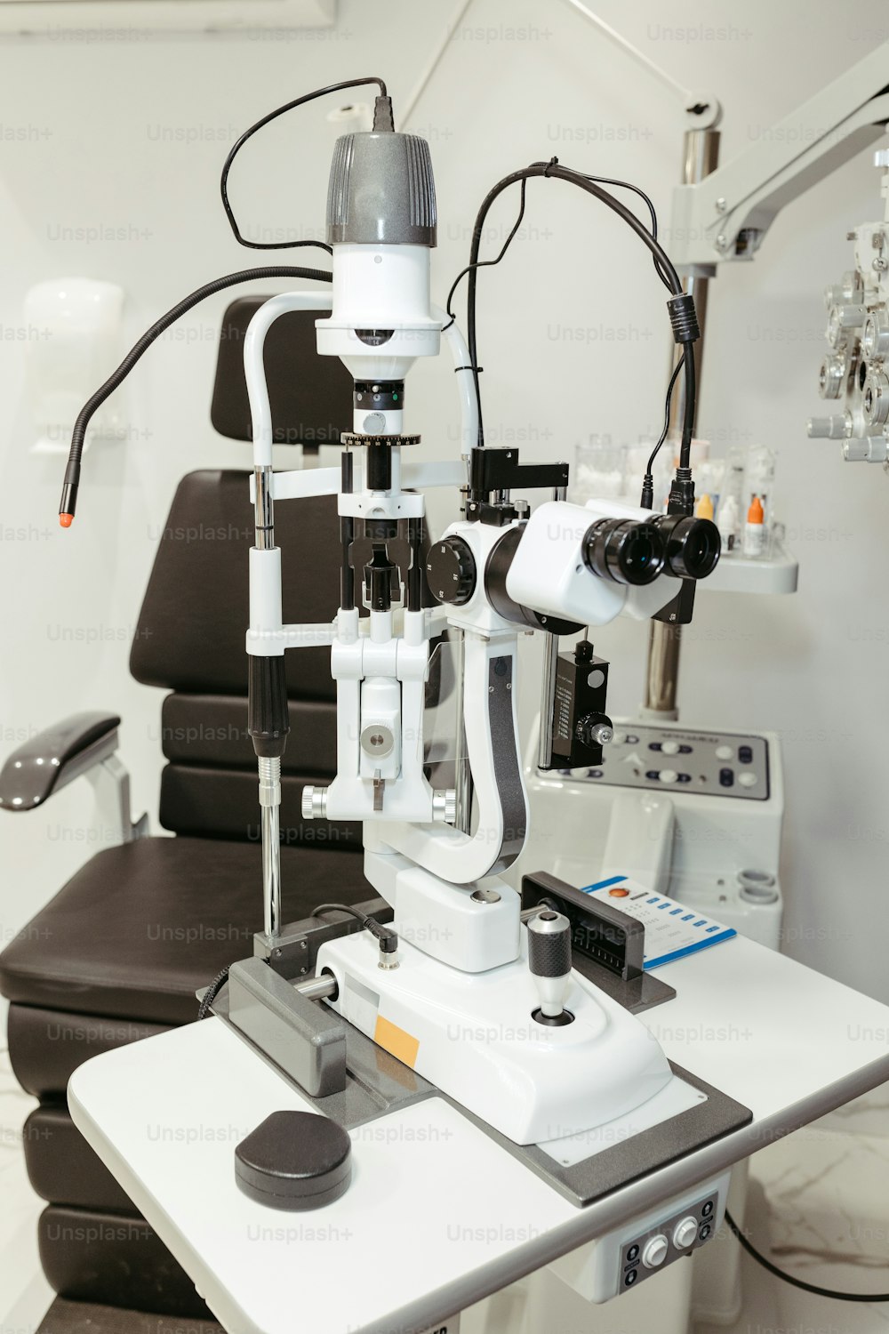 un tavolo bianco sormontato da un microscopio e un monitor