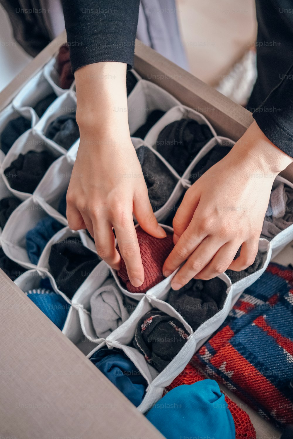 une personne mettant une paire de chaussures dans une boîte à chaussures