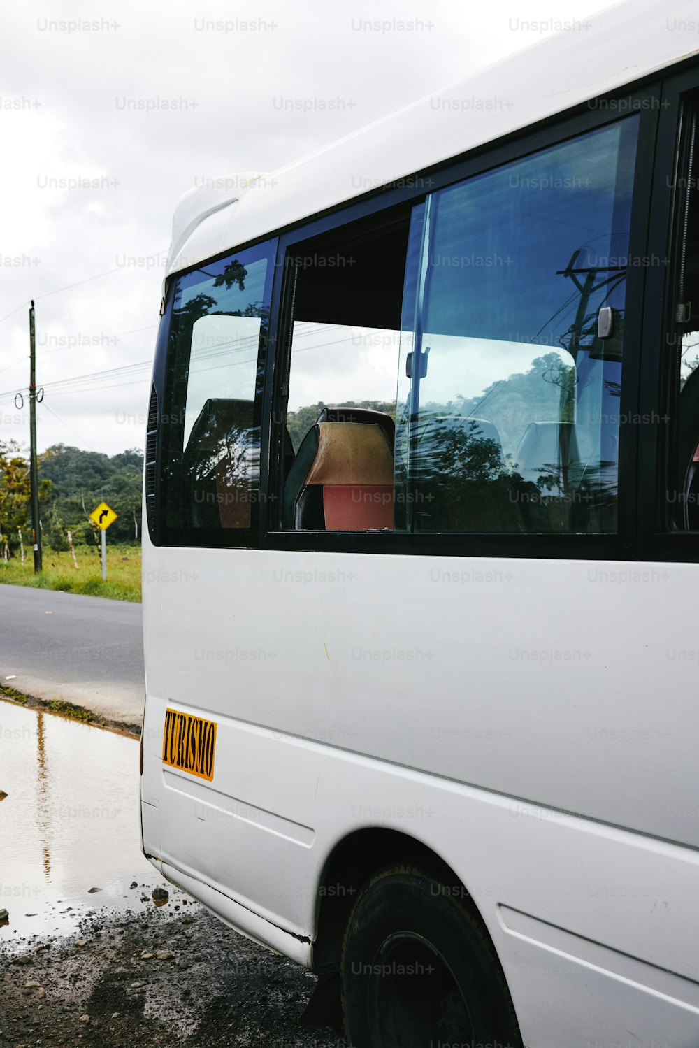 Un autobús blanco estacionado al costado de la carretera