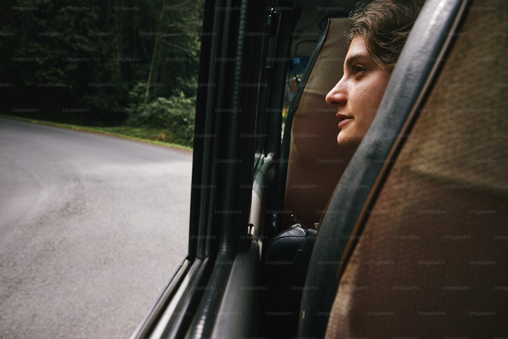 a woman looking out the window of a bus