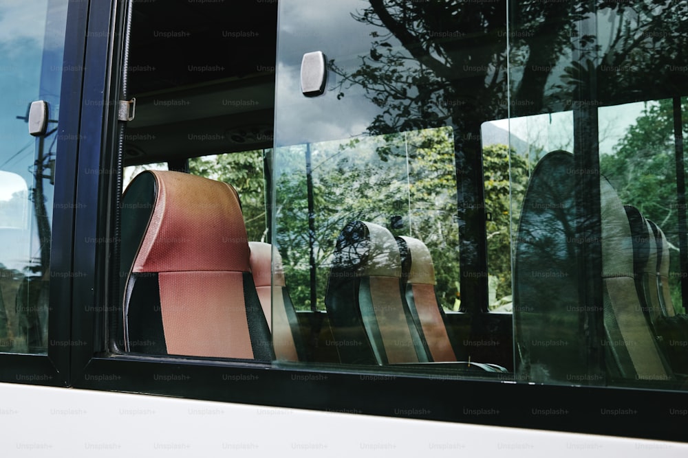 a close up of a bus window with chairs in it
