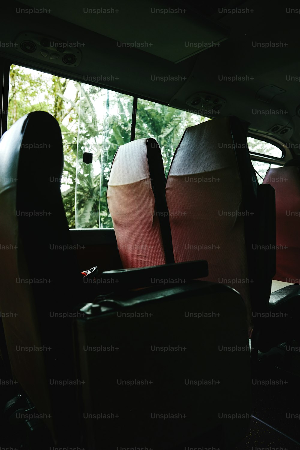 Los asientos traseros de un autobús con equipaje en el suelo