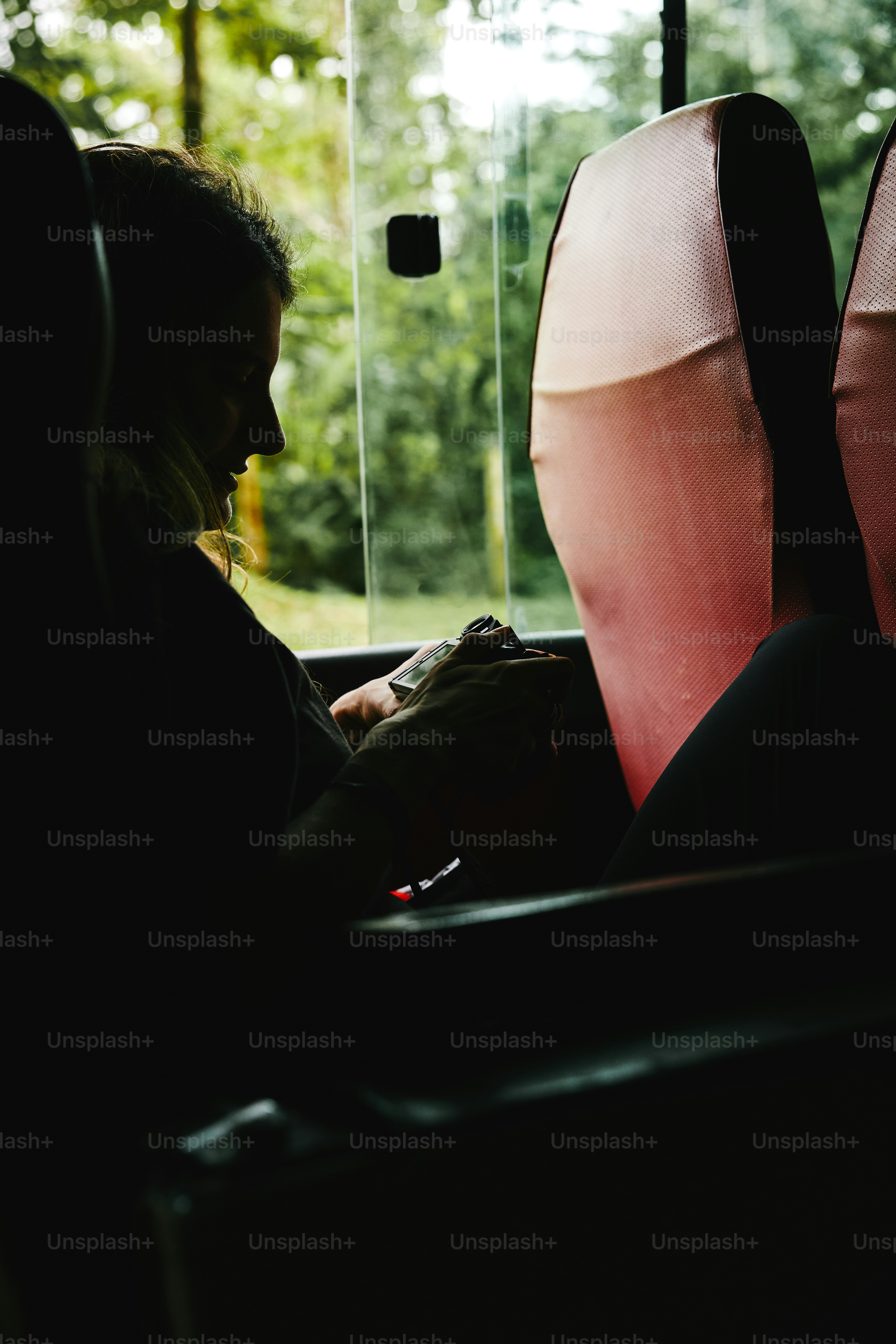 a woman sitting in a bus looking at her cell phone