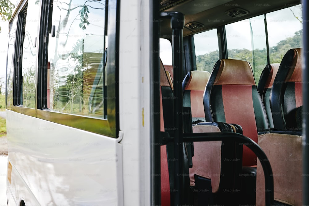 a white bus filled with lots of red and black seats