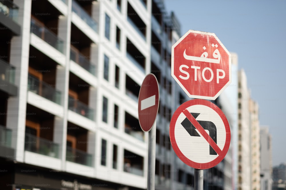 un panneau d’arrêt et un panneau d’interdiction de tourner à droite devant un immeuble