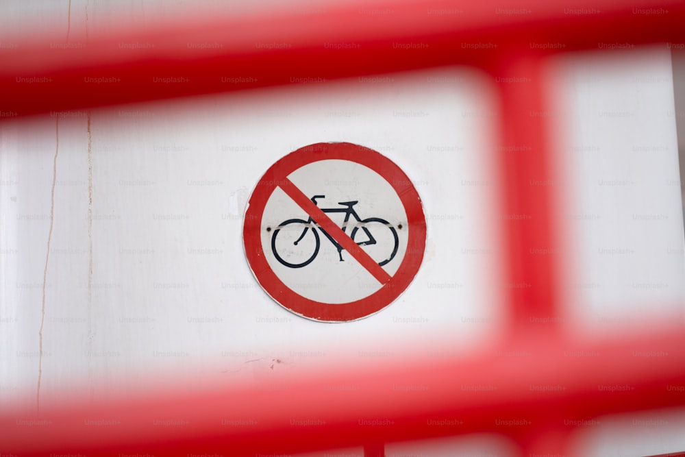 um sinal vermelho e branco com uma bicicleta nele