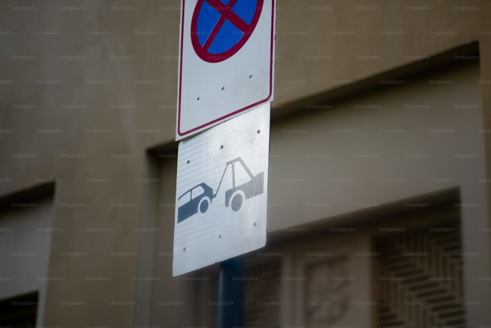 un cartello di divieto di parcheggio su un palo accanto a un edificio