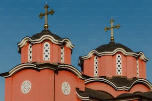 two crosses on top of a church steeple against a blue sky