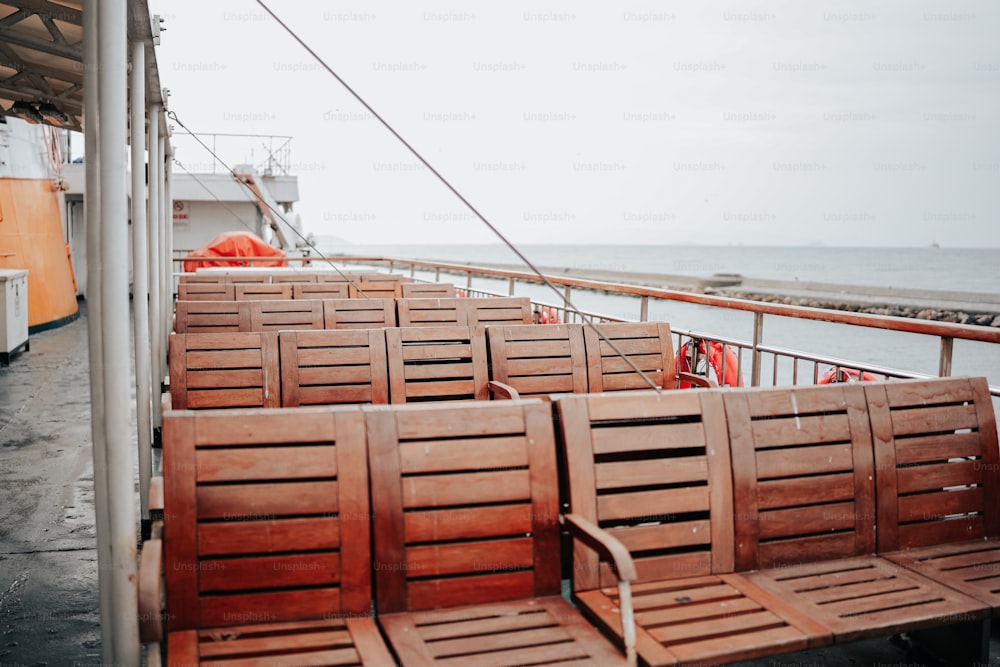 uma fileira de cadeiras de madeira sentadas em cima de um barco