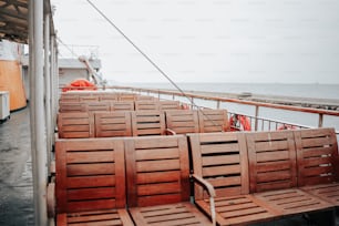 Una fila de sillas de madera sentadas encima de un bote