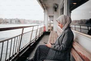 a woman sitting on a bench looking at her cell phone