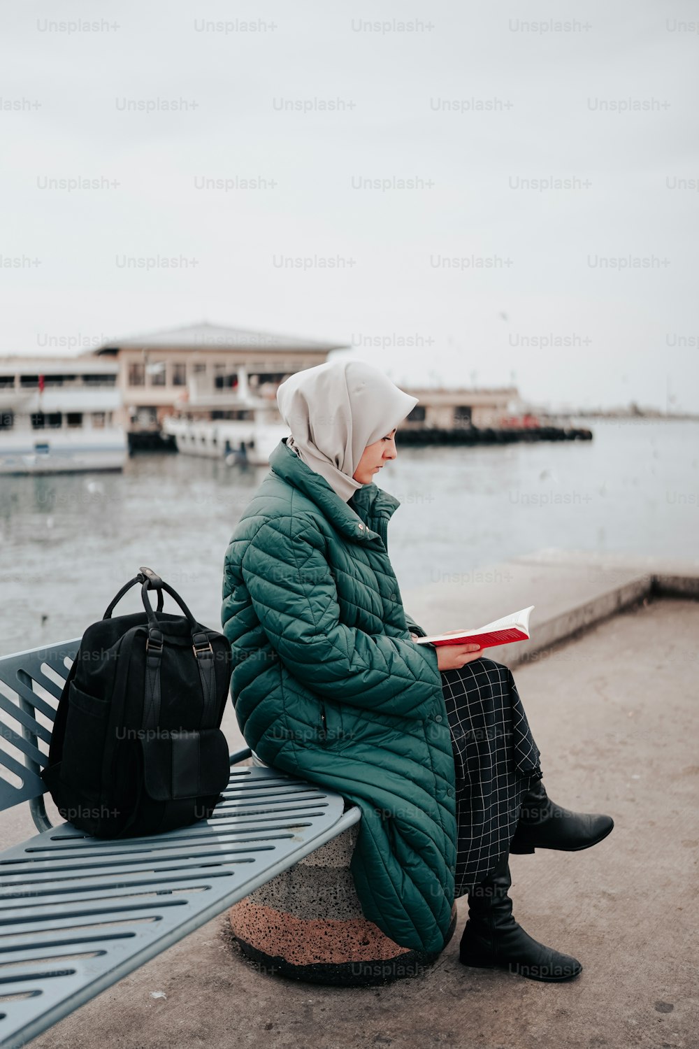 Eine Frau sitzt auf einer Bank und liest ein Buch