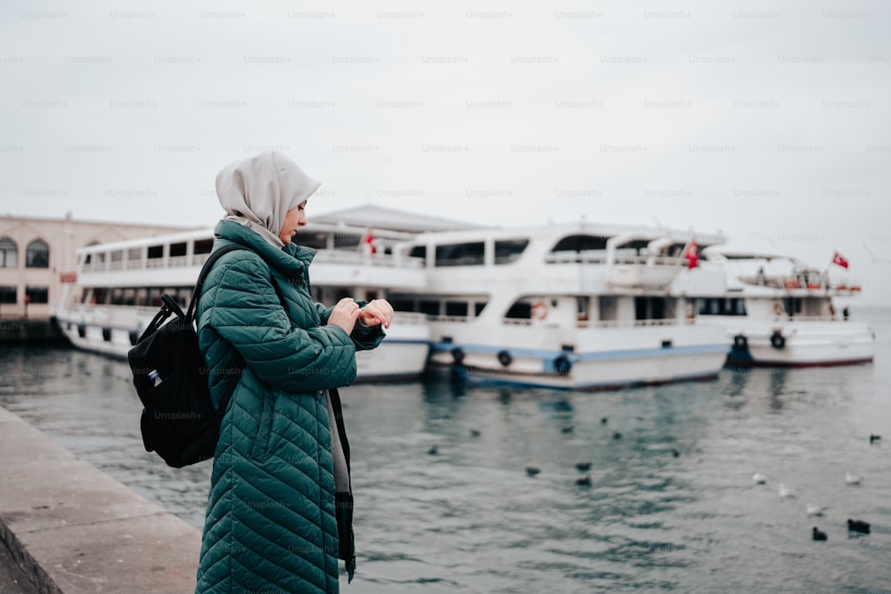 a woman standing next to a body of water