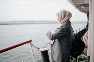 a woman standing on a boat looking out at the water