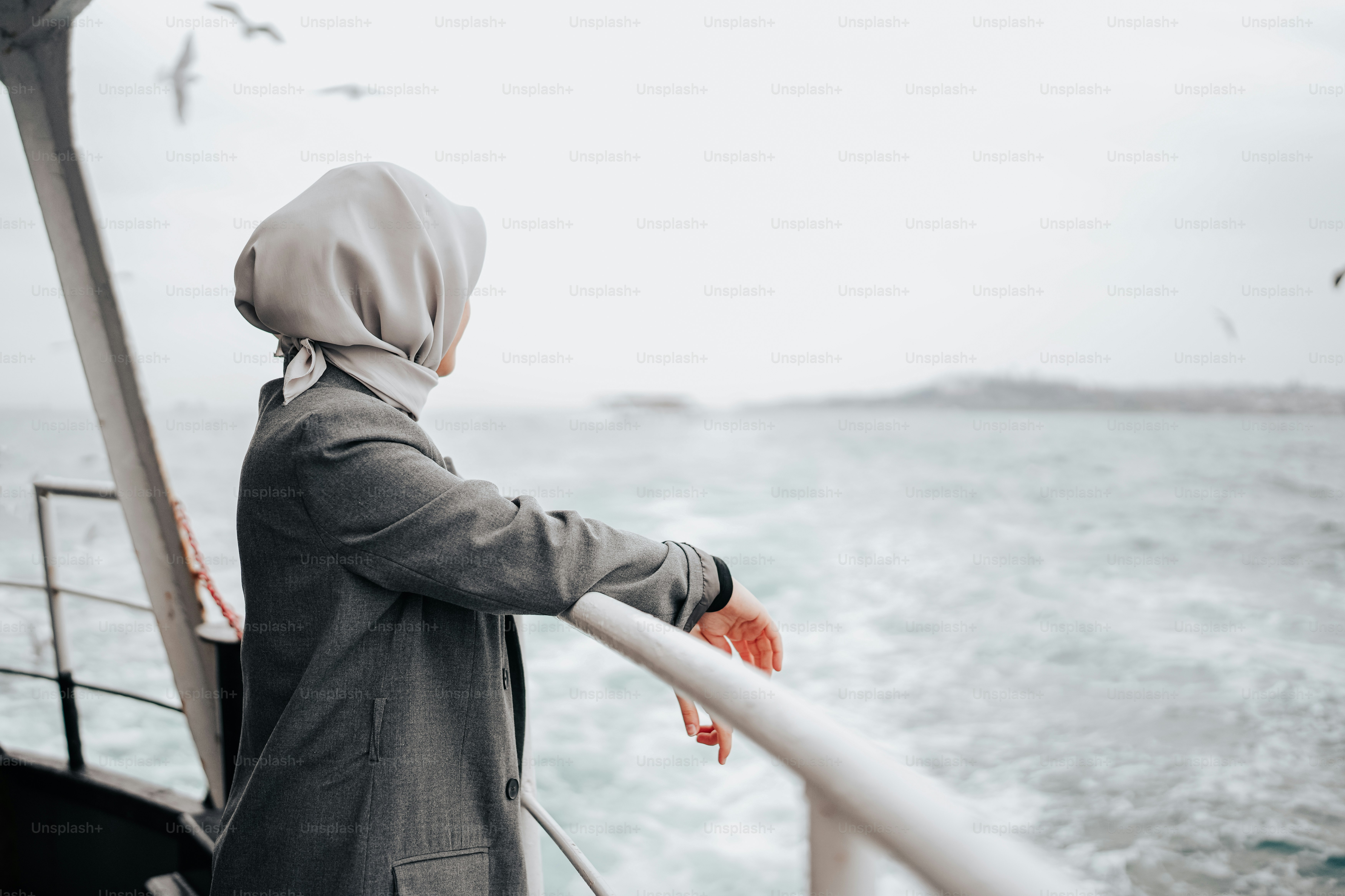 A person standing on a boat looking out at the water photo – Woman ...