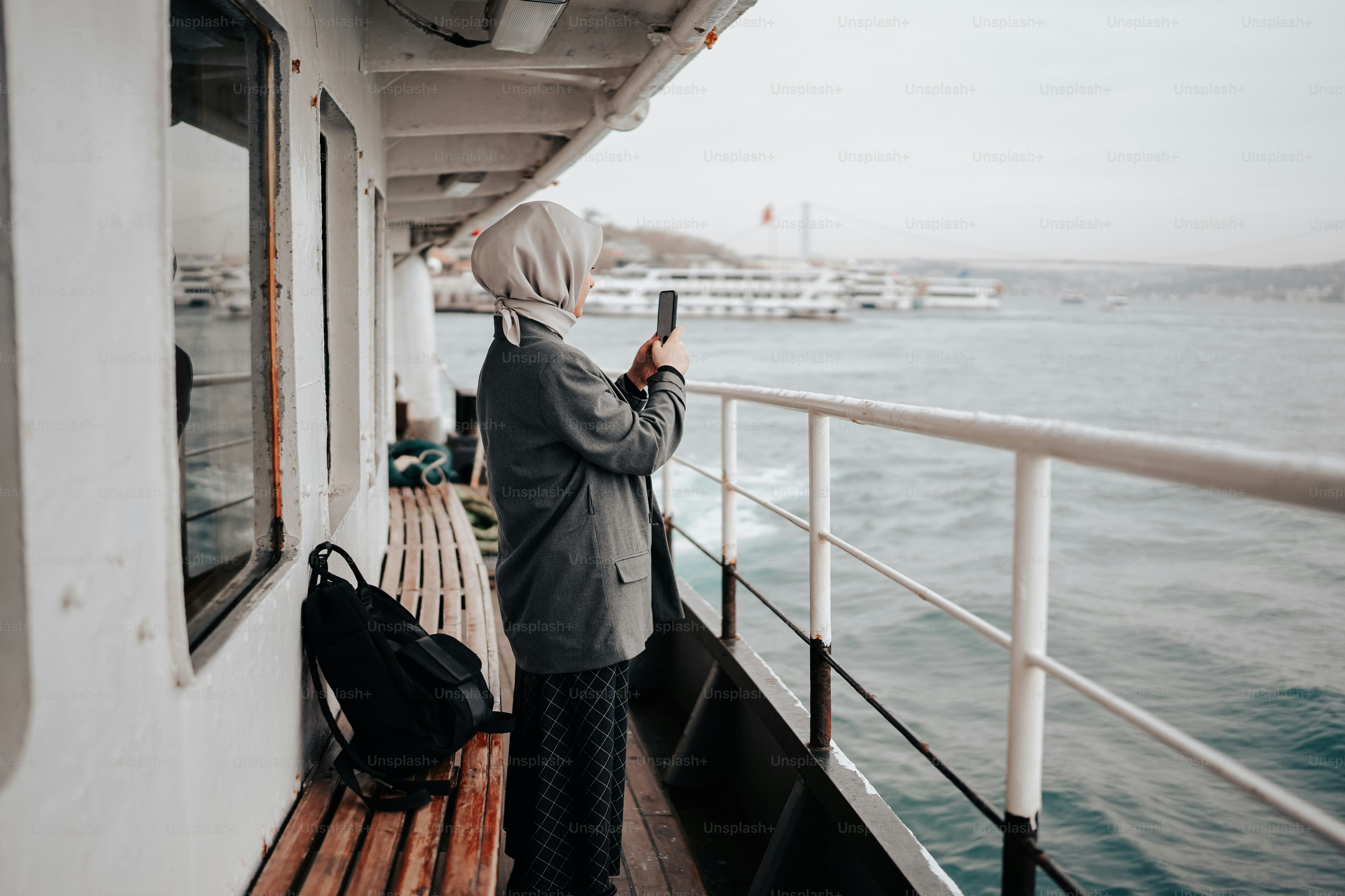 a person standing on a boat looking at a cell phone