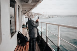 una persona in piedi su una barca che guarda un telefono cellulare