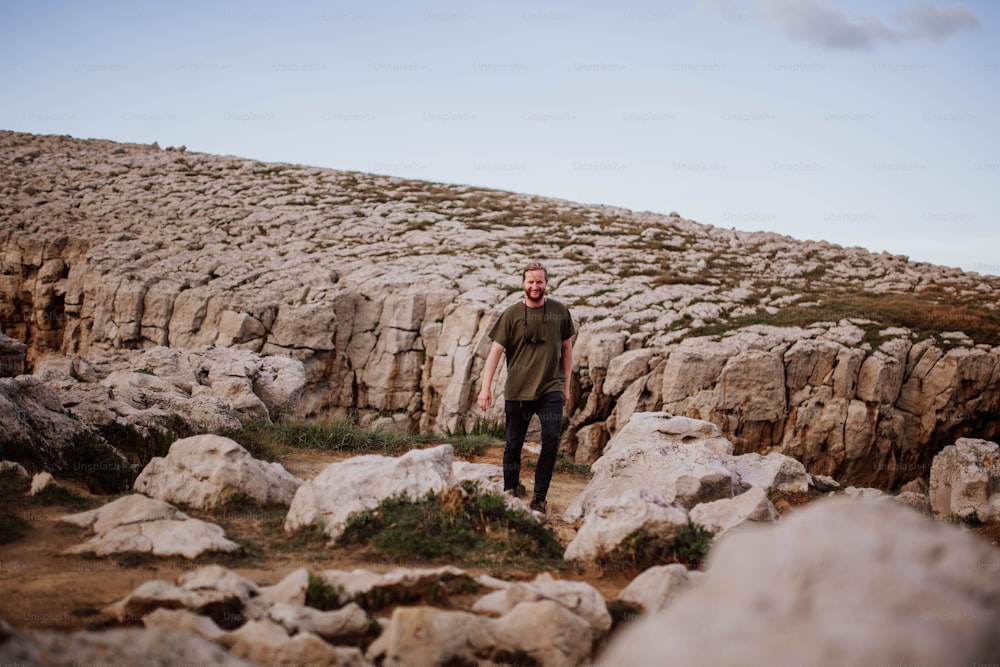 a man standing on top of a rocky hillside