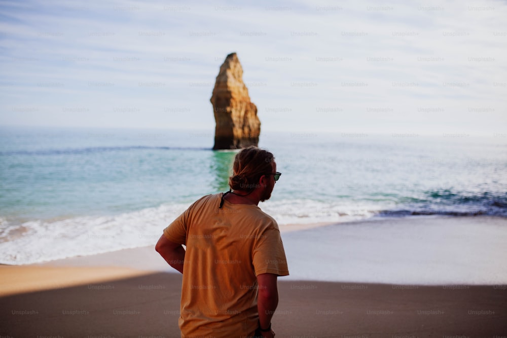 Ein Mann steht auf einem Strand am Meer