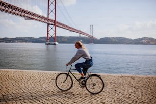 Una mujer anda en bicicleta junto al agua