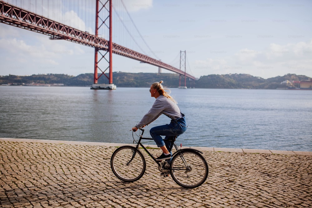 Una donna sta andando in bicicletta vicino all'acqua