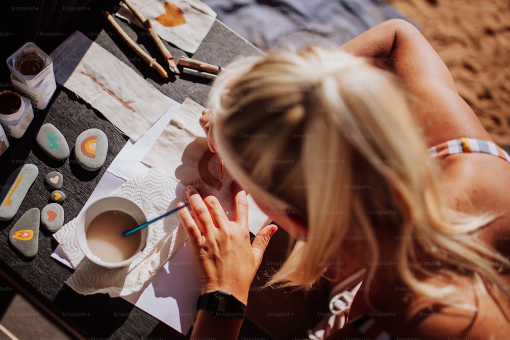 a woman is sitting at a table painting