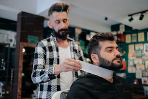 a man cutting another mans hair in a barber shop