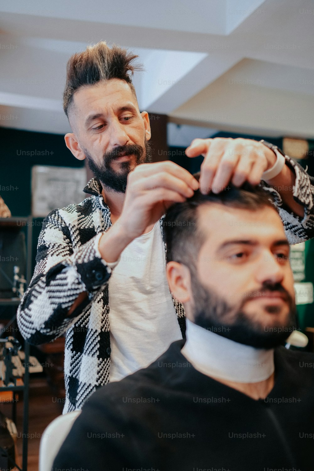 a man cutting another mans hair in a barber shop